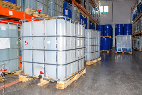 Warehouse of chemical company. Barrel storage. Pallets with containers for liquids. Plastic industrial container in lathing. Containers for chemical products. Interior of chemical products warehouse