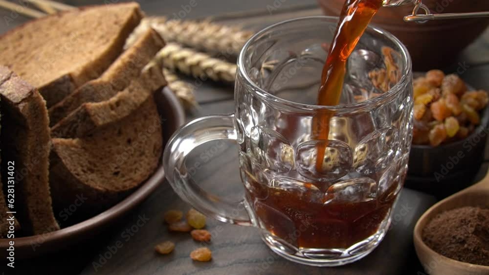 Pouring bread kvass into mug. Fermented russian traditional beverage. Pouring bread kvass into mug. Fermented russian traditional beverage.