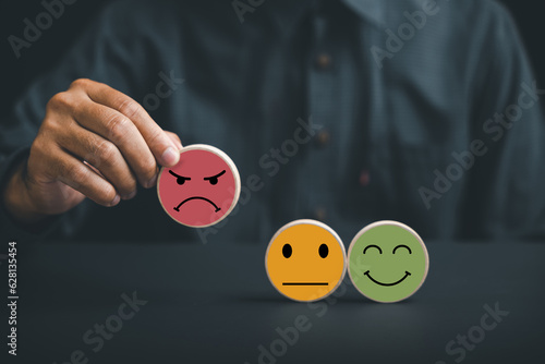 Photo Unsatisfied customer holding frown icon on wooden circle