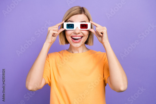 Photo of impressed girl with bob hairstyle dressed yellow t-shirt touch 3d glasses watch awesome movie isolated on violet background