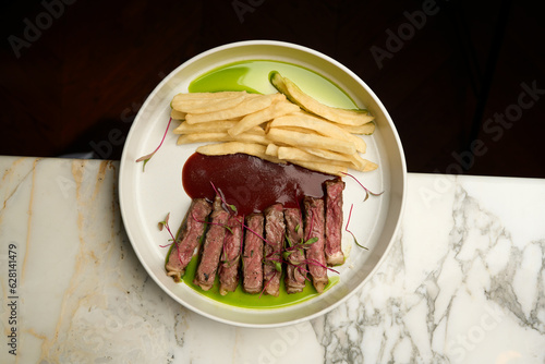 Beef steak and french fries with tomato sauce