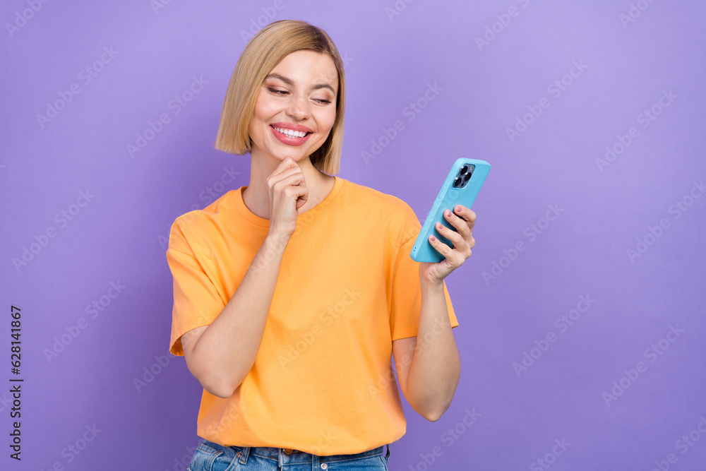 Portrait of minded clever girl dressed stylish clothes look at smartphone read interesting post isolated on violet color background Portrait of minded clever girl dressed stylish clothes look at smartphone read interesting post isolated on violet color background