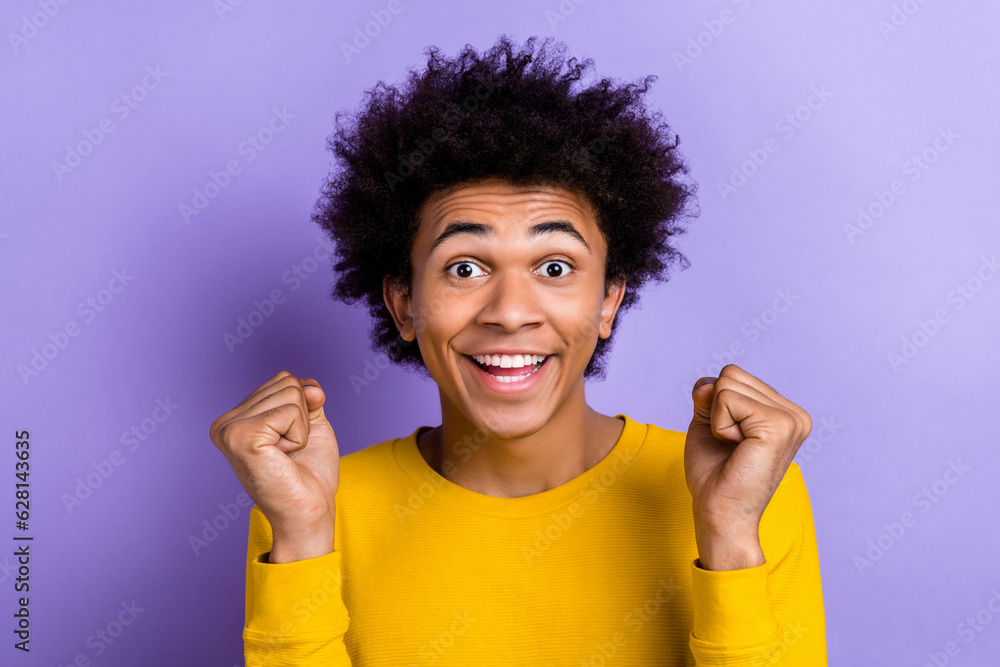 Closeup photo of youngster guy raise fists up celebrate his exam passed hooray summer holidays begin isolated on violet color background Closeup photo of youngster guy raise fists up celebrate his exam passed hooray summer holidays begin isolated on violet color background