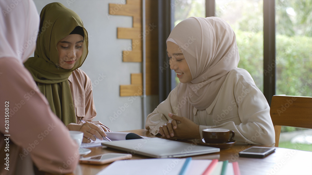 A group of successful upwardly mobile Asian Muslim friends relish a tranquil coffee shop gathering on a bright and joyful sunny day A group of successful upwardly mobile Asian Muslim friends relish a tranquil coffee shop gathering on a bright and joyful sunny day
