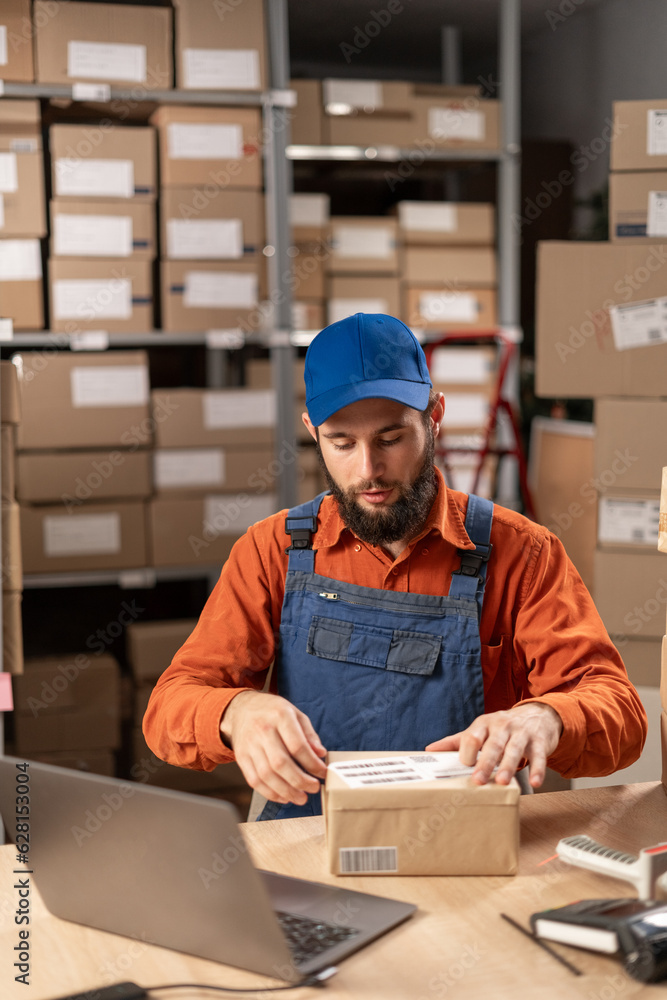 Warehouse worker applying shipping label on parcel boxes. Copy space Warehouse worker applying shipping label on parcel boxes. Copy space