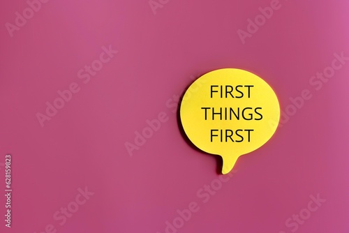 Top view image of speech bubble with text FIRST THINGS FIRST on pink background with copy space