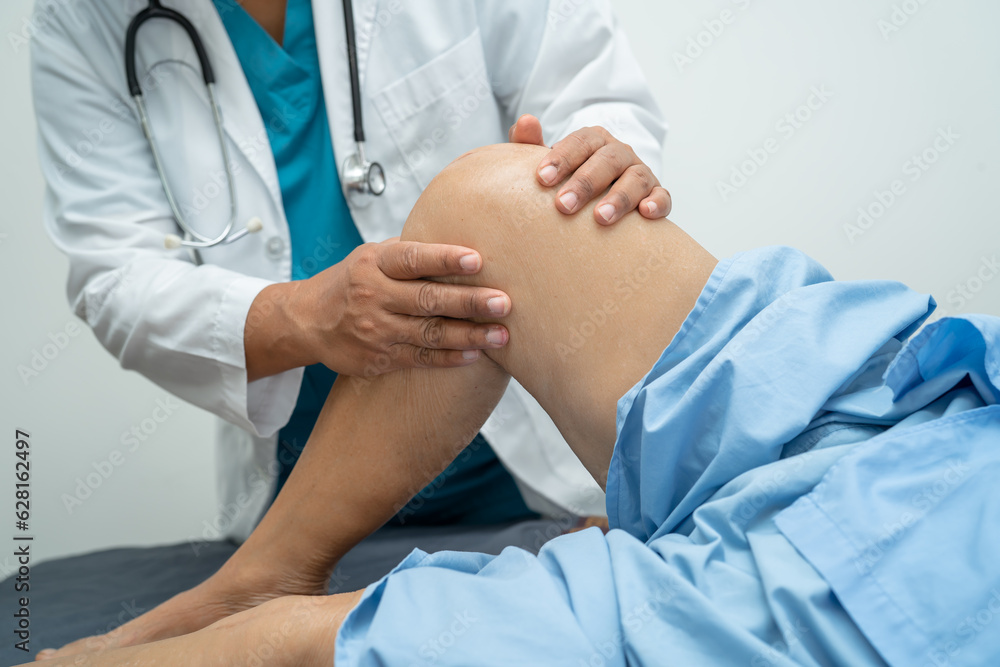 Asian elderly woman patient show her scars surgical total knee joint replacement Suture wound surgery arthroplasty on bed in hospital, healthy strong medical concept. Asian elderly woman patient show her scars surgical total knee joint replacement Suture wound surgery arthroplasty on bed in hospital, healthy strong medical concept.