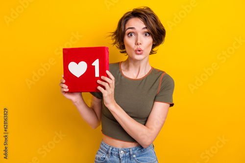 Photo of impressed funky lady wear khaki t-shirt holding feedback heart like isolated yellow color background
