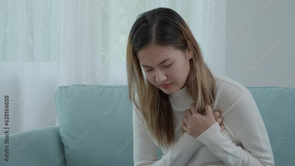 hand hold chest with heart attack symptoms, asian woman have chest pain caused by heart disease, leak, dilatation, enlarged coronary heart, press on the chest with a painful expression hand hold chest with heart attack symptoms, asian woman have chest pain caused by heart disease, leak, dilatation, enlarged coronary heart, press on the chest with a painful expression