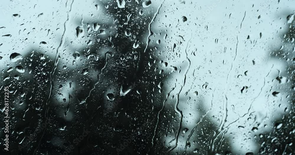 Raindrops falling on a car windshield. Inside view, close up shot, selective focus, bokeh. moody, no people Raindrops falling on a car windshield. Inside view, close up shot, selective focus, bokeh. moody, no people