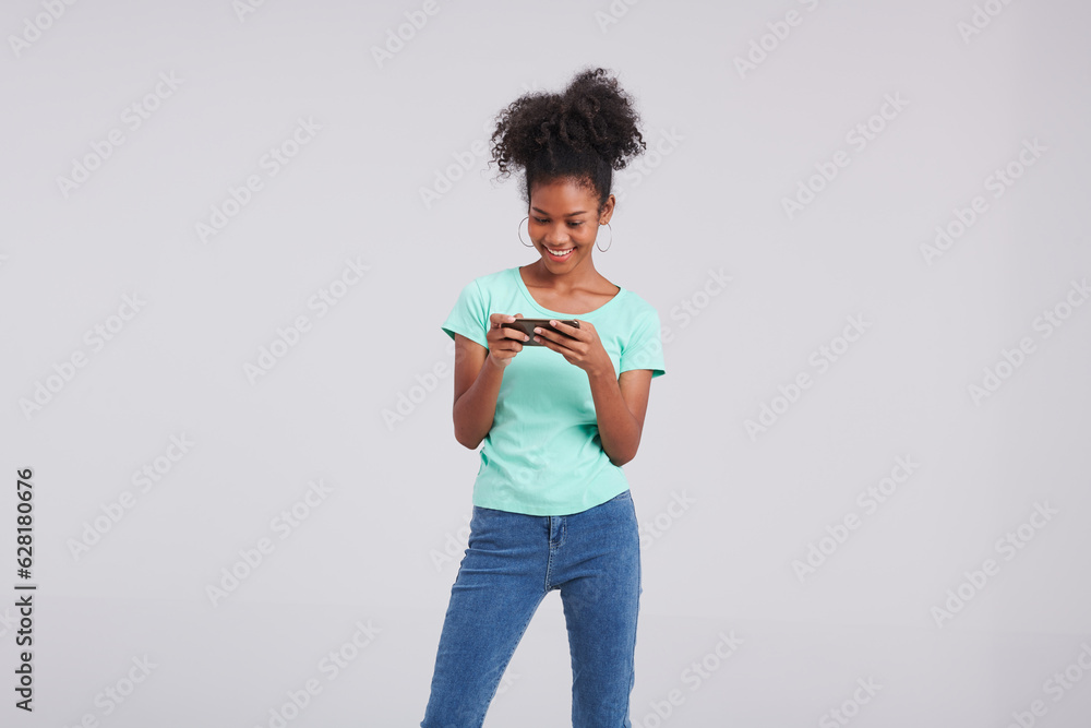 Φωτογραφία Connected couture, a Thai American woman poses in a mint shirt and blue jeans, combining her smartphone with fashion during the studio shoot