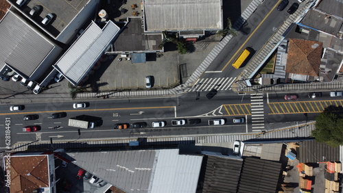 Cruzamento de trânsito de carros na cidade de Mogi das Cruzes em São Paulo no Brasil vista do alto por um drone em um dia de sol.  photo