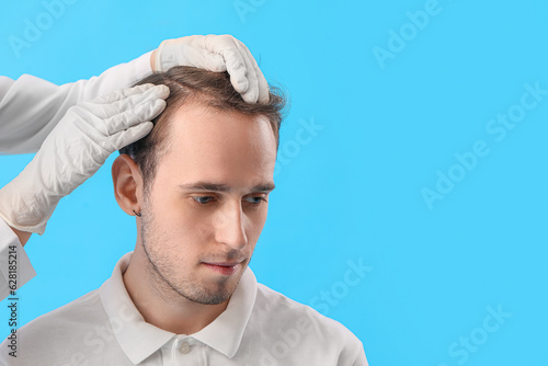 Doctor examining young man'...