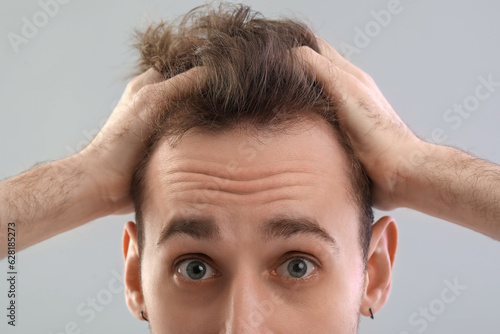 Shocked young man with hair...