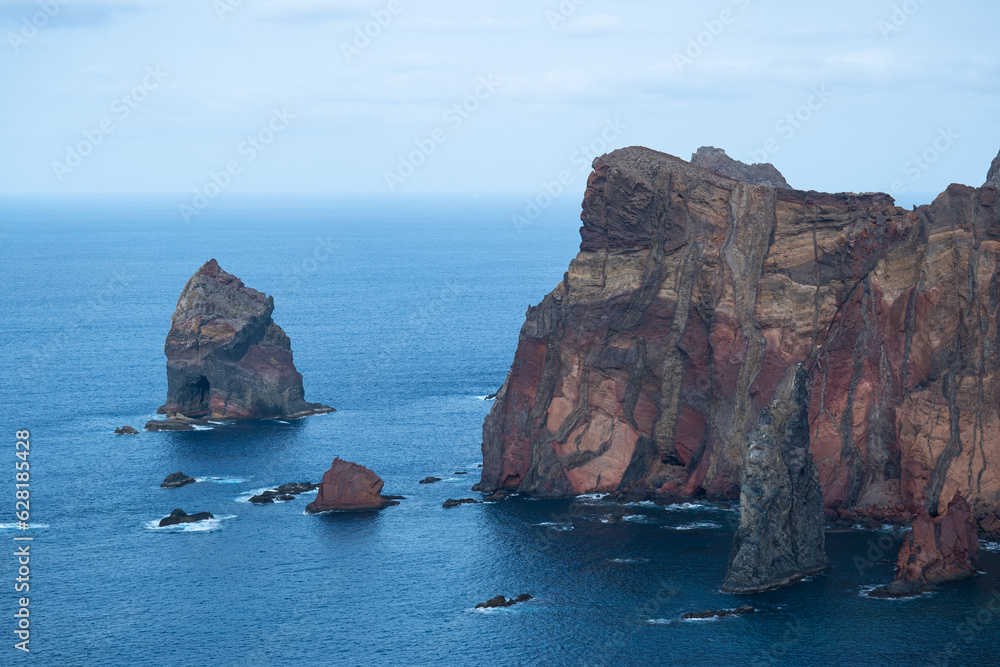 Fototapeta premium Massive orange cliffs and rocks at the Atlantic Ocean coast in madeira