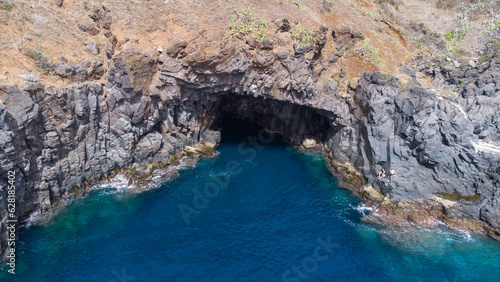 Aerial view of rocky cliffs on the coast of Madeira at the Atlantic ocean with clear blue water