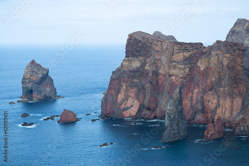 Massive orange cliffs and rocks at the Atlantic Ocean coast in madeira