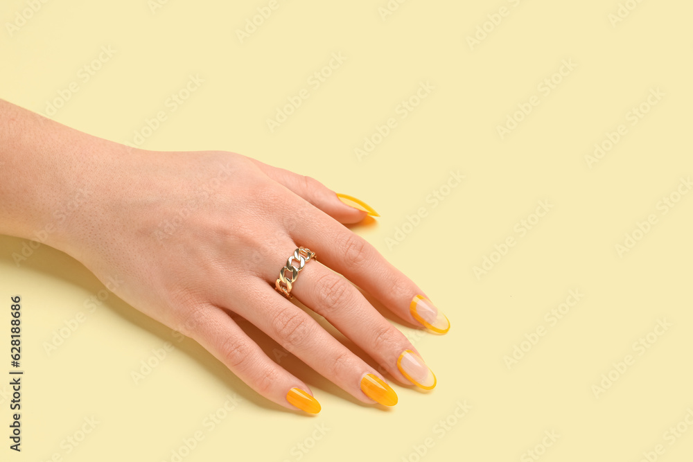 Fototapeta premium Woman with press-on nails on yellow background