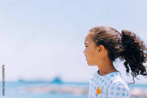 young girl looking at beach on summer day