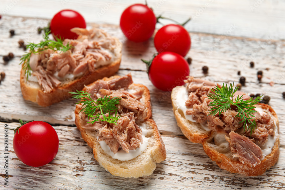 Delicious tuna bruschettas with tomatoes and peppercorn on white wooden table Delicious tuna bruschettas with tomatoes and peppercorn on white wooden table