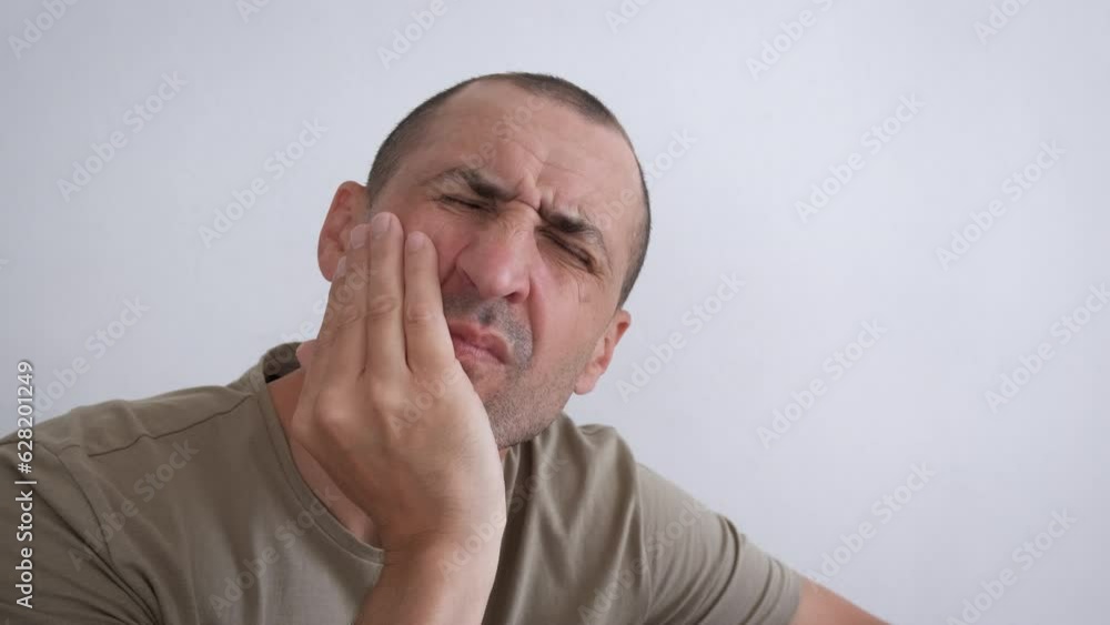 Male with toothache attack. A sad man has a tooth ache attack in the