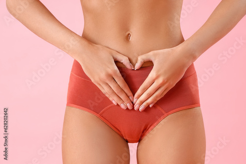 Young woman in menstrual panties on pink background, closeup © Pixel-Shot