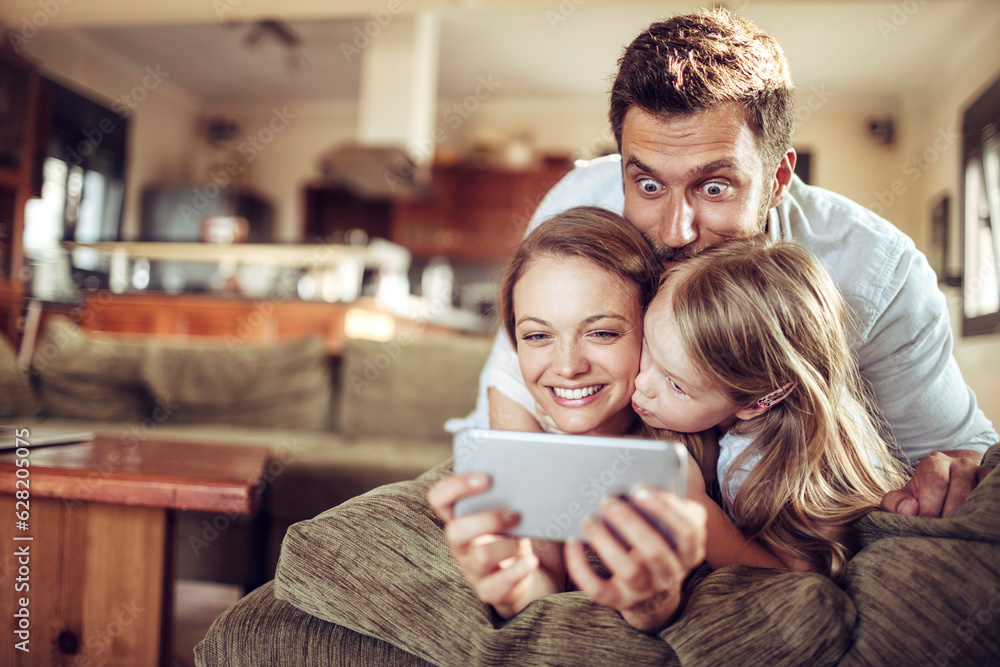 Young family taking a selfie on the couch in the living room Young family taking a selfie on the couch in the living room
