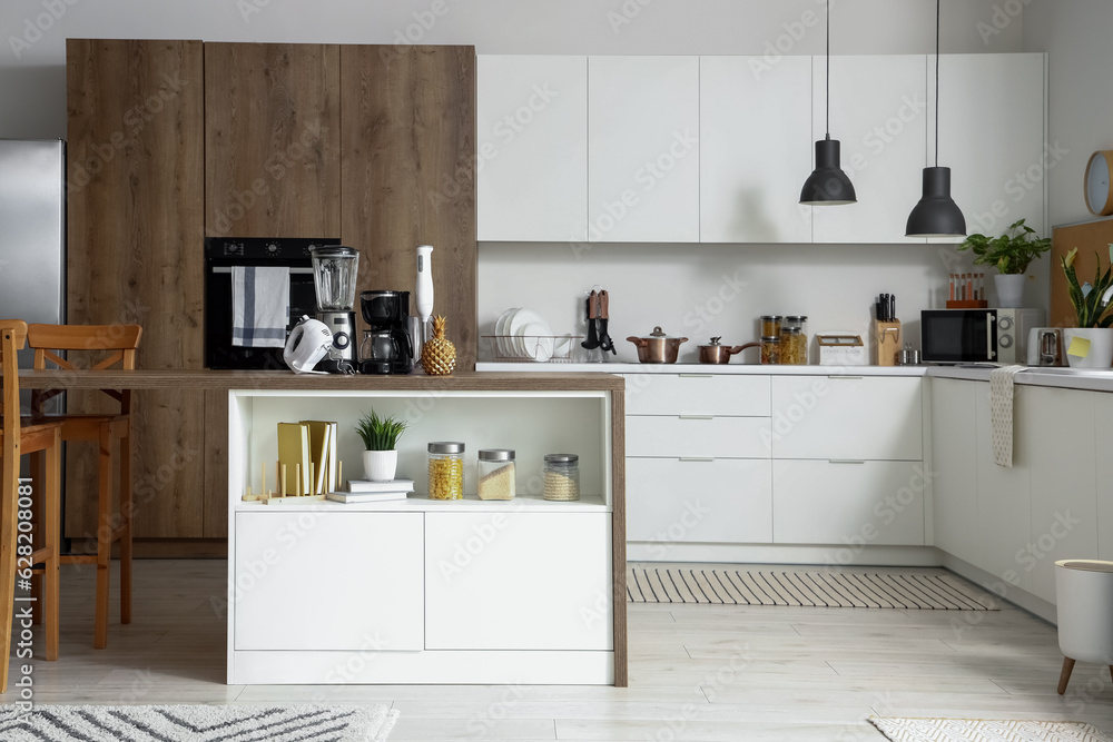 Interior of light kitchen with modern appliances on wooden table Interior of light kitchen with modern appliances on wooden table