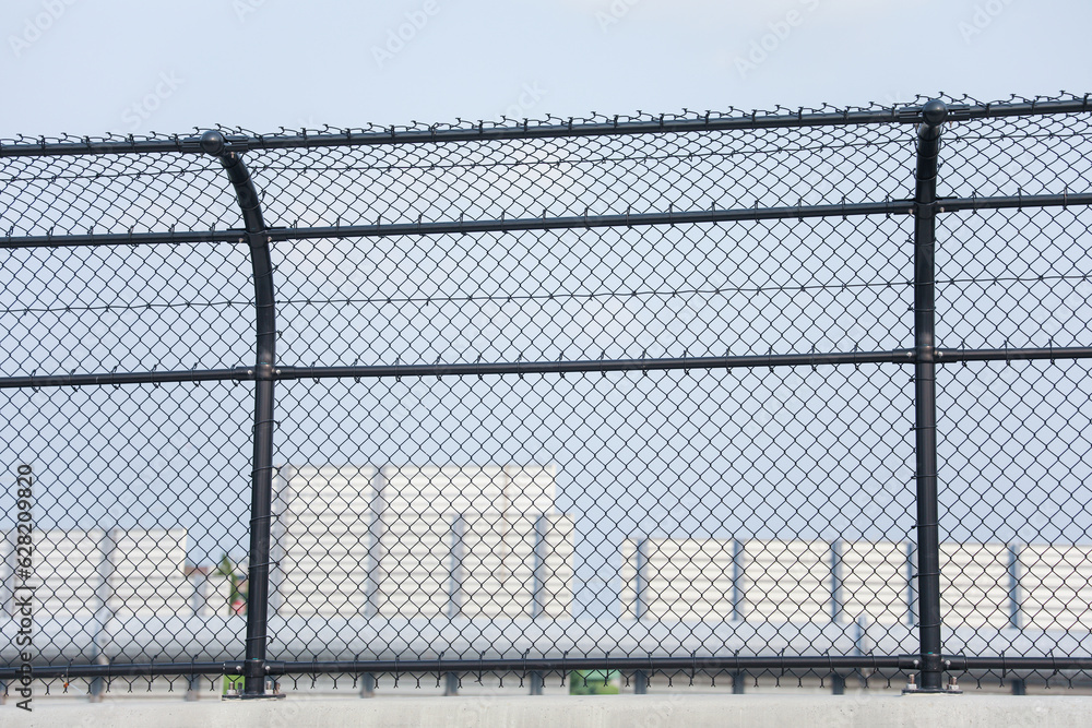 Chain-link fence symbolizes boundaries, security and isolation. Metaphor for protection and confinement. Concept of division and connection