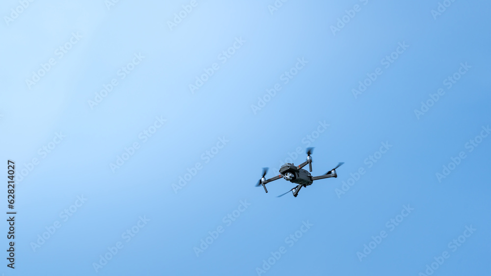 A surveillance drone in front of blue sky A surveillance drone in front of blue sky