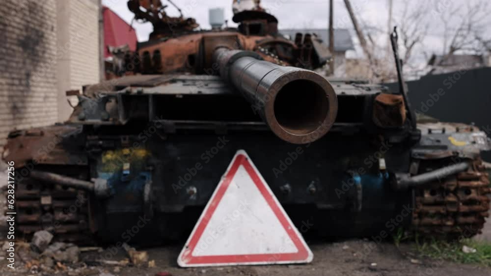 Russian tank, Conflict impacts, Road wreckage. Amidst Russian-Ukrainian conflict, Russian battle tank was reduced to rubble on streets of city. Russian tank, Conflict impacts, Road wreckage. Amidst Russian-Ukrainian conflict, Russian battle tank was reduced to rubble on streets of city.
