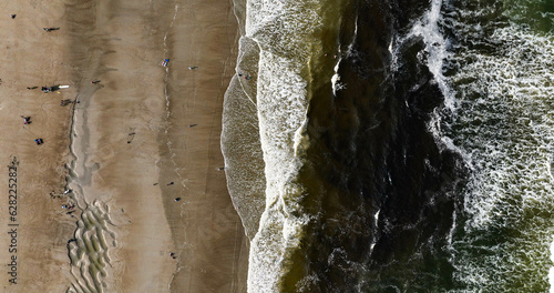 Aerial, split view of sand and water on Ogunquit Beach in Ogunquit Maine.