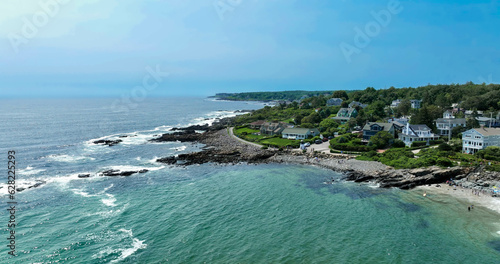 Maine rocky coast with crashing waves and aerial view of marginal way running and walking path.