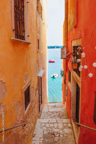 Narrow street between old houses leading to the sea in Rovinj