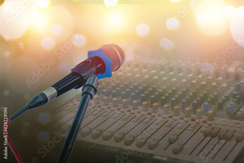 Microphone on blurred background and sound mixer equipment.