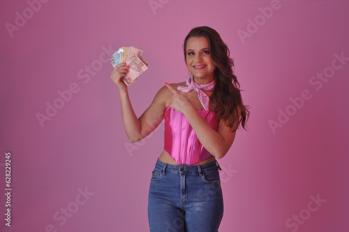 bela mulher jovem segurando masso de dinheiro, lucro, faturamento, loteria, vencedora, empresária photo