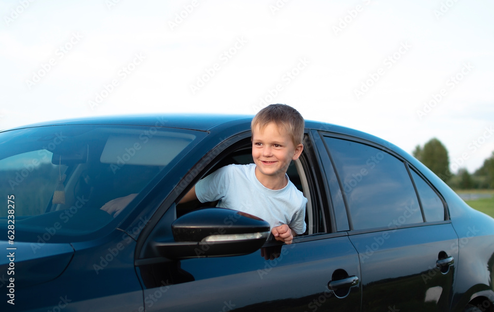 Little boy in the car is happy at the wheel of car holding steering wheel Little boy in the car is happy at the wheel of car holding steering wheel