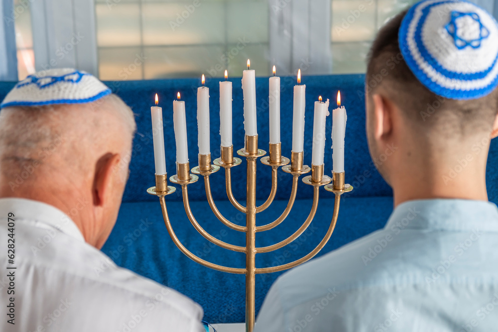 Foto de Hanukkah holiday. A senior man and young guy wear kippahs on