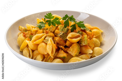 Conchiglie rigate pasta. Macaroni in shape of ridged shell with courgette and tomato sauce with parsley leaves in white dish isolated
