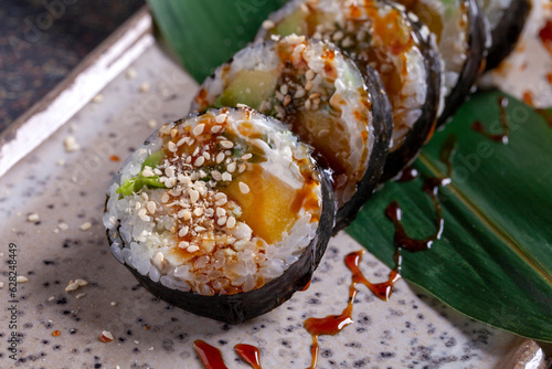 aSushi roll with eel, cucumber and sesame seeds