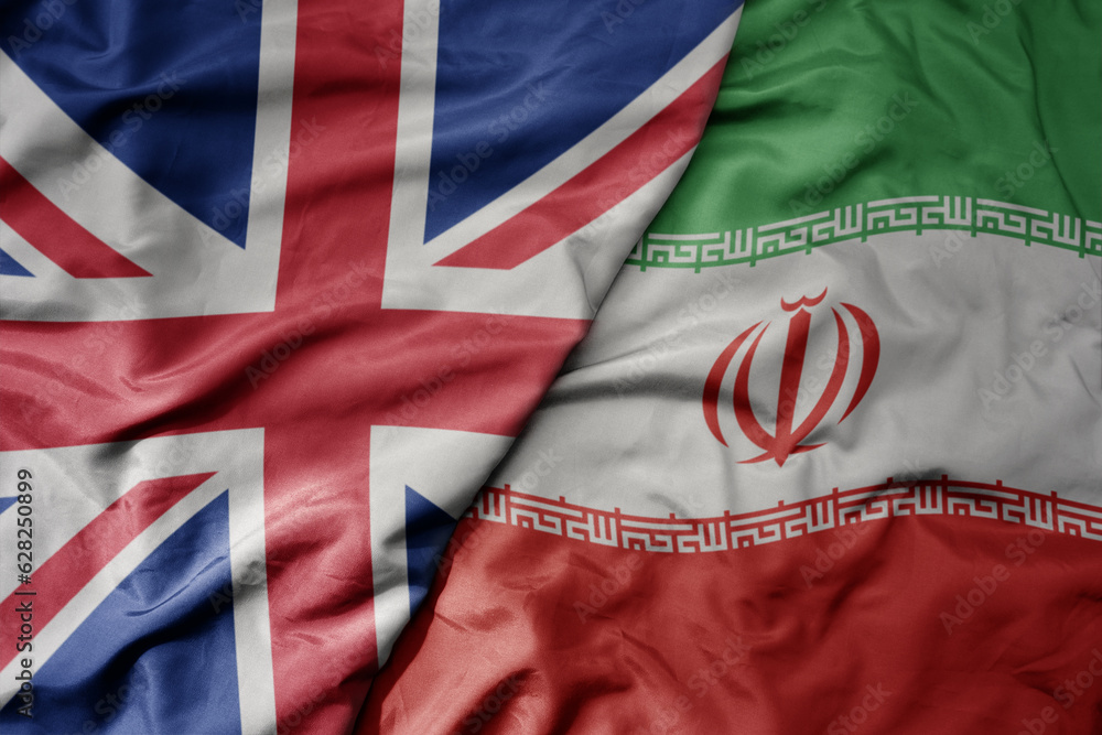 Fototapeta premium big waving national colorful flag of great britain and national flag of iran .