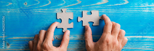 Valokuva Male hands matching two blank puzzle pieces