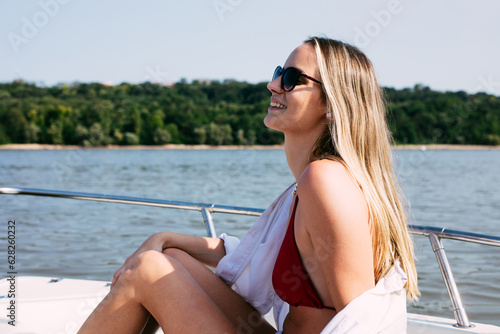 Smiling happy woman in summer on board of yacht