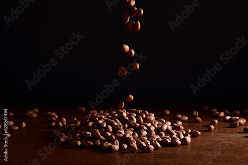 Grão de amendoim caindo em fundo preto photo