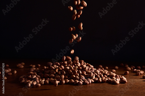 Grãos de amendoim caindo em fundo preto photo