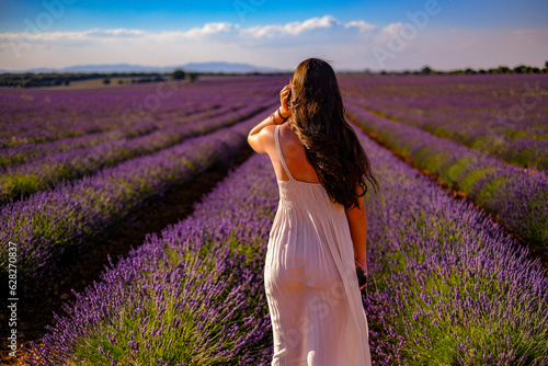 Una joven observa el atardecer en los campos de lavanda en Brihuega, España donde este cultivo tiñe de morado el paisaje en verano