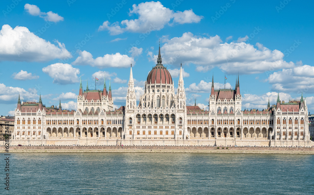Fototapeta premium Hungarian Parliament building in Budapest, Hungary. View across Danube River, with summer clouds.