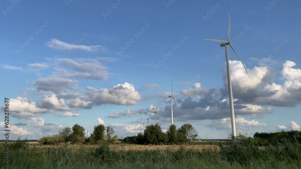 a row of wind turbines stands in the farmland,moving motion,4K, real time a row of wind turbines stands in the farmland,moving motion,4K, real time
