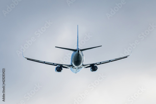 Flying jet passenger plane in the sky, rear view