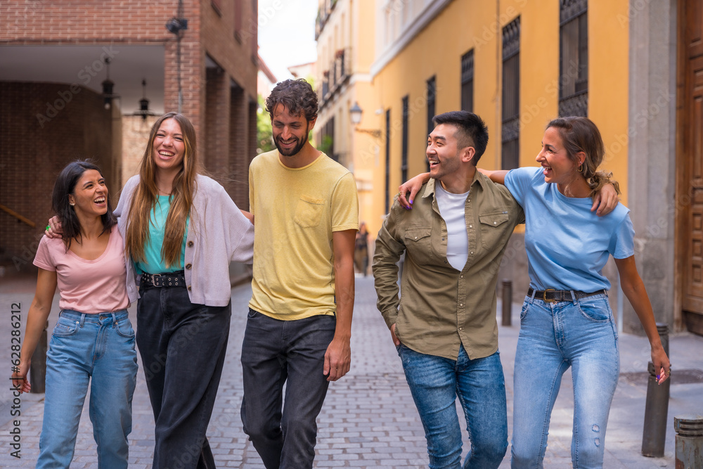 Group of multiracial friends embracing smiling in the city, friendship concept with guys and girls hanging out in the city street Group of multiracial friends embracing smiling in the city, friendship concept with guys and girls hanging out in the city street